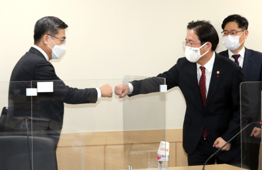 성윤모 산업통상자원부 장관(왼쪽)과 서욱 국방부 장관이 19일 정부서울청사에서 열린 제7회 국방산업 발전협의회에서 주먹인사하고 있다. 연합뉴스